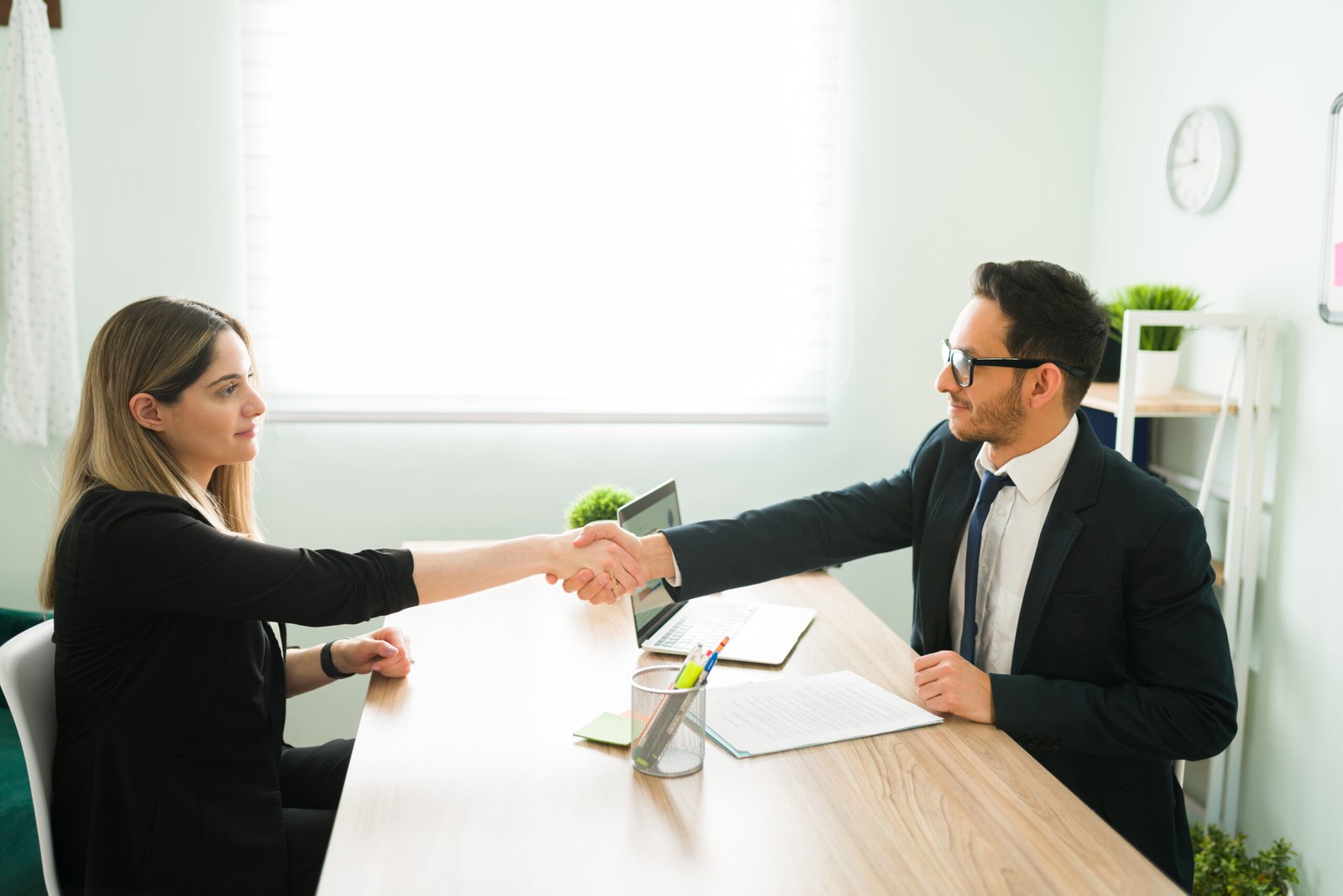 male human resources manager suit shaking hands with attractive professional woman after hiring her new job scaled